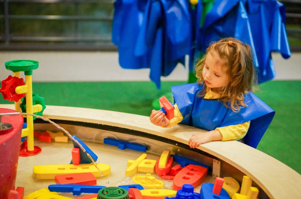 cute,baby,girl,is,playing,with,water,in,museum