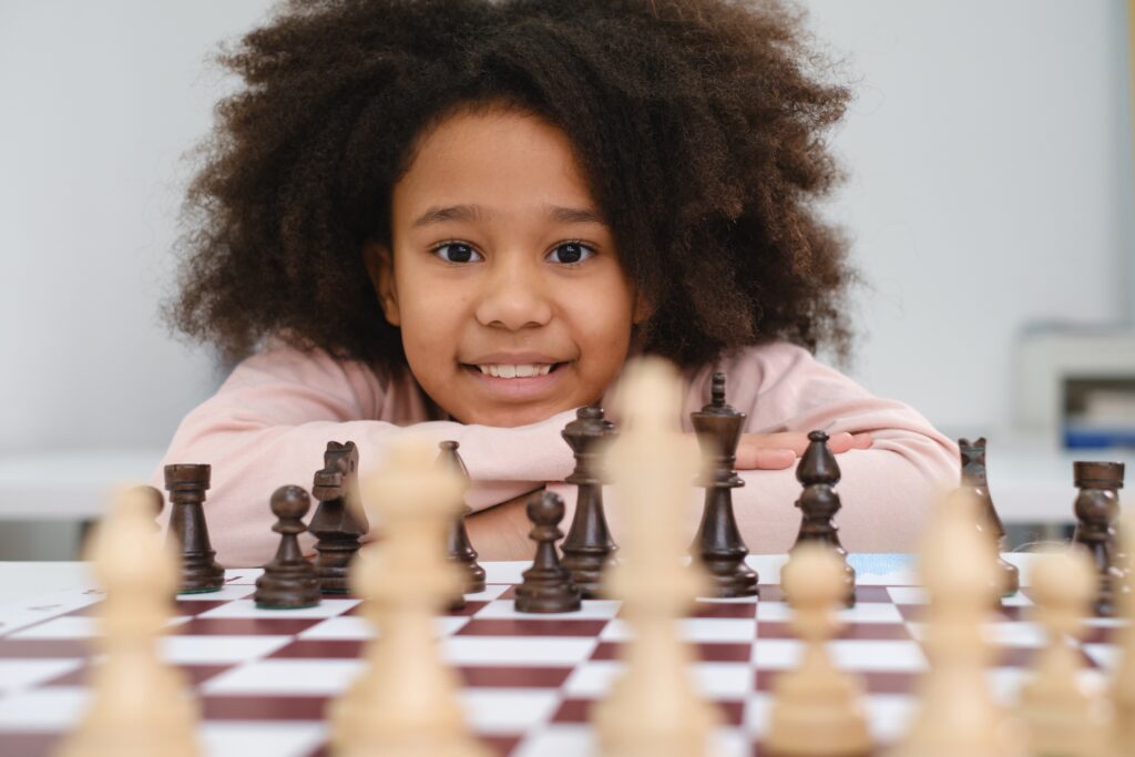 african,american,girl,playing,chess.,happy,smiling,child,behind,chess